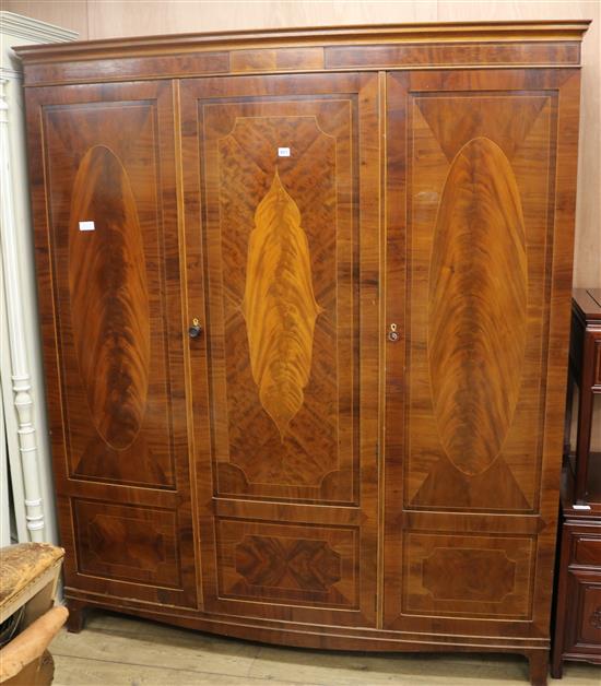 An Edwardian inlaid mahogany bowfront three door wardrobe, W.174cm